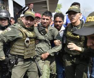 Policías colombianos escoltan a una mujer miembro de las Fuerzas Armadas Nacionales Bolivarianas de Venezuela que desertó, cerca del puente internacional Simón Bolívar en Cúcuta, Colombia.