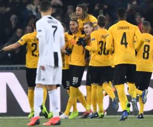 Young Boys' players celebrate after scoring their team's first goal next to Juventus' Portuguese forward Cristiano Ronaldo (L) during the UEFA Champions League group H football match between Young Boys and Juventus at the Stade de Suisse stadium on December 12, 2018 in Bern. (Photo by Fabrice COFFRINI / AFP)