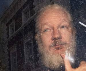 Julian Assange levanta su pulgar al momento de ser subido a un vehículo tras su captura. (Foto: AP)