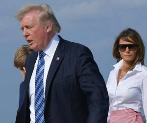 Donald Trump, presidente de los Estados Unidos, baja del avión junto a su esposa. (AFP)