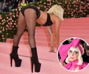 Lady Gaga desfiló por la alfombra roja con pestañas doradas y un enorme vestido fucsia del que se fue desprendiendo capa por capa hasta quedar en sostén y medias de red. Foto: Agencias AFP/AP.