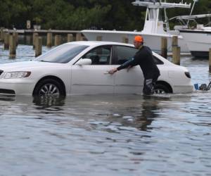 Weston Rice conduce a través de un estacionamiento inundado mientras se prepara para lanzar su moto de agua al agua en el Centro Marino Haulover antes de la llegada del huracán Dorian el 30 de agosto de 2019 en Miami Beach, Estados Unidos. Fotos: Agencia AFP.