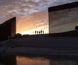 En esta imagen del 10 de junio de 2021, un par de familias de inmigrantes brasileños cruzan por una apertura en el muro fronterizo desde México hacia Yuma, Arizona, con el fin de solicitar asilo. (AP Foto/Eugene Garcia, archivo).