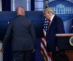 Momento en que el presidente de Estados Unidos, Donald Trump, era sacado de la rueda de prensa. AFP.