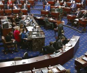Los senadores se apiñaron en la cámara alta mientras los líderes hablaban con los empleados en el estrado. Foto: AP.