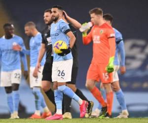 El centrocampista argelino del Manchester City, Riyad Mahrez (C), se va con el balón del partido después de anotar un hattrick en el partido de fútbol de la Premier League inglesa entre Manchester City y Burnley en el Etihad Stadium en Manchester, noroeste de Inglaterra. Manchester City ganó el juego 5-0. Laurence Griffiths / PISCINA / AFP