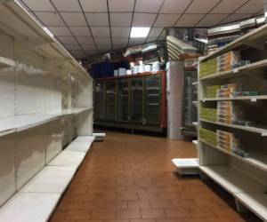 Los estantes de los supermercados lucen vacíos. Foto AFP