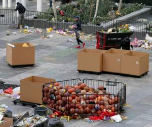 Trabajadores retiran miles de artículos dejados como ofrenda para Kobe Bryant en la Plaza X-Box, frente al Staples Center de Los Ángeles. (AP Foto/Reed Saxon)