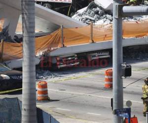 Los vehículos son vistos atrapados bajo el puente peatonal colapsado que fue construido recientemente sobre la calle 8 suroeste permitiendo a la gente eludir la concurrida calle para llegar a la Universidad Internacional de Florida. Foto AFP