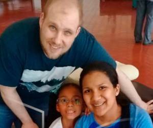 En esta foto distribuida por la familia Holt, Joshua Holt posa con su esposa Thamara y la hija de ella en el aeropuerto de Caracas, sábado 26 de mayo de 2018.
