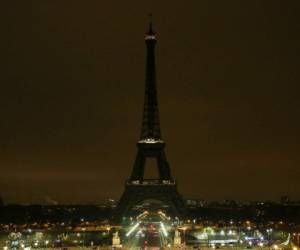 Las luces de la Torre Eiffel se oscurecen a medianoche del 23 de marzo de 2018 en París. Foto AFP