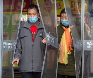 Dos personas con mascarillas salen de una tienda Walmart en Beijing, el sábado 1 de febrero de 2020. La cifra de muertos por un nuevo virus en China ha aumentado a 259 y un funcionario de la Organización Mundial de la Salud dice que otros gobiernos deben prepararse controlar 'brotes locales' si la enfermedad se propaga. Foto: AP.