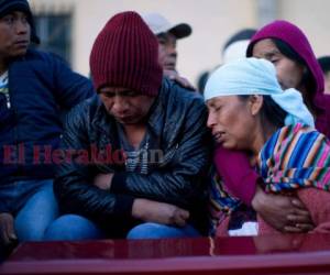 Una mujer llora junto a un ataúd que contiene los restos de una víctima de un accidente de tránsito en Nahuala, Guatemala, jueves 28 de marzo de 2019.