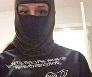 La mujer se mostró con el rostro cubierto, vistiendo una camisa con el logo del mapa de México donde se aprecia el número 866 y un rifle.