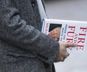 Un hombre lleva un ejemplar del libro Fire and Fury.