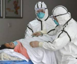 Personal sanitario provisto con trajes protectores traslada a una paciente infectada con coronavirus a un pabellón de aislamiento en el Segundo Hospital del Pueblo en Fuyang, provincia de Anhui, en el centro de China. Foto: AP.