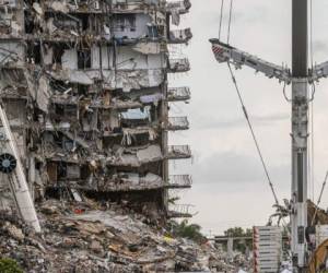 En esta foto de archivo, los equipos de búsqueda y rescate buscan posibles sobrevivientes en el edificio de condominios Champlain Towers South de 12 pisos, parcialmente derrumbado, el 28 de junio de 2021 en Surfside, Florida. Foto: AFP