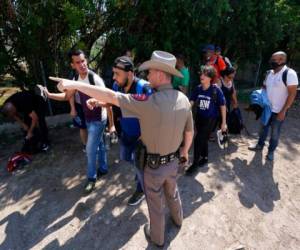 Un agente del Departamento de Seguridad Pública en Del Rio, Texas, dirige hacia un lugar a un grupo de migrantes que cruzaron la frontera y se entregaron a las autoridades. (AP Foto/Eric Gay, Archivo).