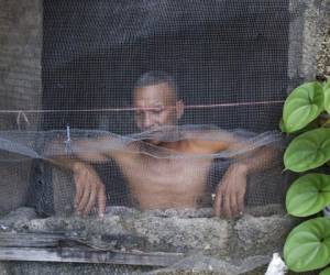 Un hombre observa por su ventana en Caracas, Venezuela. El representante de la FAO recordó también que es mas barato apoyar la producción de alimento que subsidiar el que esa población no pudo recibir. Foto: AP.