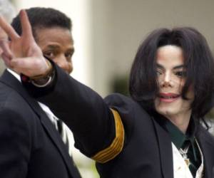 En esta foto del 2 de marzo del 2005, Michael Jackson saluda a sus fans al llegar a su juicio por abuso de menores en la Corte Superior del Condado de Santa Bárbara en Santa María, California.(Foto: AP)