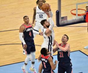 El pivot de los Grizzlies de Memphis Jonas Valanciunas lanza el balón mientras lo defiende Moritz Wagner y Troy Brown Jr. de los Wizards de Washington. Foto:AP