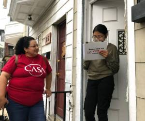 Mirna Orellana, a la izquierda, organizadora comunitaria para el grupo sin fines de lucro We Are Casa, ayuda a Karyme Navarro, a la derecha, a rellenar un formulario para registrarse como votante en York, Pensilvania. Foto: AP.