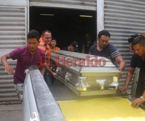 Familiares de Jeferson Gutiérrez sacan el ataúd de la morgue. Foto: Stalin Irías/EL HERALDO