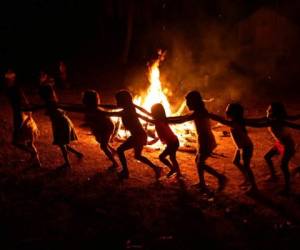 Niños de la tribu brasileña de los Tenetehara juegan alrededor de una fogata durante un festival en la Tierra Indígena Alto Río Guamá, donde aplicaron un aislamiento obligatorio de seis meses durante la pandemia de coronavirus. Foto AP