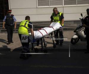 Operarios sacan un cadaver en una camilla, en el exterior de una comisaría de policía tras un ataque en Cornella de Llobregat, cerca de Barcelona. (Foto: AP)