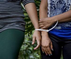 En esta foto de archivo del 8 de diciembre de 2016, dos mujeres que son acusadas de ser parte de la pandilla de la Mara Salvatrucha (MS-13) son presentadas ante la prensa en instalaciones de la policía en San Salvador. AP.