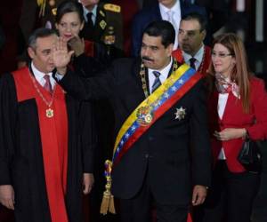 El presidente venezolano Nicolás Maduro saluda, junto al presidente del Tribunal Supremo de Venezuela, Maikel Moreno y la primera dama venezolana Cilia Flores, a su llegada para una ceremonia de inauguración del año judicial en la Corte Suprema de Justicia de Caracas. Foto AFP