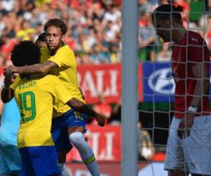 El delantero brasileño Neymar celebra la anotación con sus compañeros de equipo durante el partido amistoso internacional de fútbol Austria vs Brasil en Viena, el 10 de junio de 2018. / AFP / JOE KLAMAR.