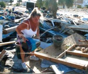En esta fotografía del 14 de octubre de 2018, Dena Frost mueve una vasija de los escombros de su negocio en la localidad de Mexico Beach, Florida.