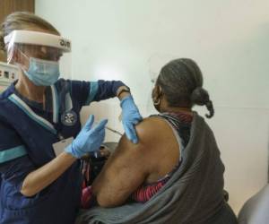 La estudiante de enfermería Chasity Violet vacuna a Carol Mitchell, residente del sur de Los Ángeles, con su primera dosis de la vacuna de Pfizer contra el COVID-19 en la clínica de MLK Community Medical Group en Los Ángeles, el miércoles 24 de febrero de 2021. (AP Foto/Damian Dovarganes).