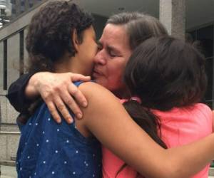 Marta es abrazada por dos de sus hijas tras salir de su cita con el ICE. Foto: Fe en Acción