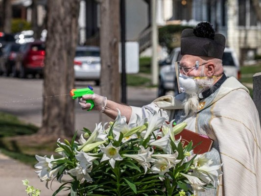 El sacerdote Tim Pelc es quien lanza el agua a los feligreses. Foto: Cortesía.