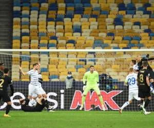 El portero ucraniano del Dynamo Kiev, Heorhiy Bushchan, se mantiene alerta mientras el delantero danés del Barcelona Martin Braithwaite salta de cabeza durante el partido de fútbol del grupo G de la Liga de Campeones de la UEFA entre el Dynamo Kiev y el Barcelona en el estadio Olympiyskiy en Kiev. Foto: AFP.