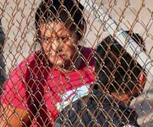 Una mujer esposada mira a través del alambrado en Koch Foods Inc., en Morton, Misisipi. Foto: AP.