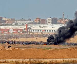 El kibutz israelí del sur de Nahal Oz, al otro lado de la frontera con la Franja de Gaza, muestra a los manifestantes palestinos reunidos a lo largo de la cerca fronteriza con Israel (trasfondo). Foto AFP