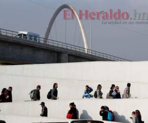 Un hondureño que sólo se identificó como Ariel, centro de camisa azul, cruza a Estados Unidos para comenzar su caso de petición de asilo mientras otros son regresados a México, el martes 19 de marzo de 2019 en Tijuana, México. (AP Foto/Gregory Bull)