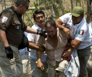 Un centroamericano es detenido por agentes federales que se inmiscuyeron en la caravana, algunos vestidos de civil, para sorprender al grupo y poder arrestarlos. (Foto: AP)