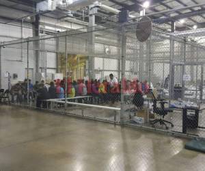Cientos de jóvenes inmigrantes son mantenidos detrás de una reja de metal, como una jaula de bateo de barrio o una perrera, dentro del centro de procesamiento de inmigración más grande del país. Fotos AFP