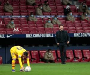 El técnico Diego Simeone del Atlético de Madrid grita instrucciones mientras el delantero Lionel Messi se prepara para ejecutar un tiro libre en el partido por La Liga de España. (AP Foto/Bernat Armangue)
