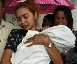 La madre carga a su bebé de 11 meses luego de enterarse que había muerto. Foto: AFP/DailyNews