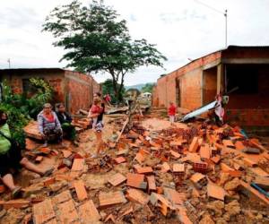 En fotos oficiales se ven casas de tejas y ladrillos destrozadas, árboles derribados y una capa de lodo que cubre el suelo, mientras adultos y niños damnificados tratan de recuperar pertenencias en medio de los escombros. Foto: AFP