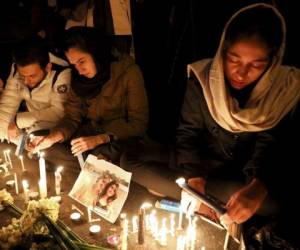 Gente durante una vigila por las víctimas del derribo de un avión de pasajeros ucraniano, en la entrada de la Universidad Amri Kabir en Teherán. Foto: AP.