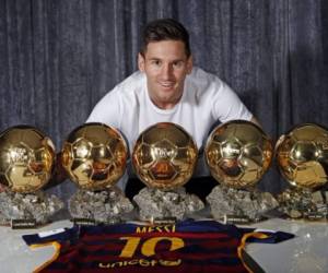 El astro del Barcelona, Lionel Messi, posa junto a sus cinco Balones de Oro.