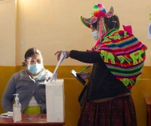 Una mujer indígena quechua vestida con atuendo típico étnico emite su voto en un colegio electoral en la remota aldea rural de Capachica, en Puno, Perú, cerca de la frontera con Bolivia. Foto: AFP