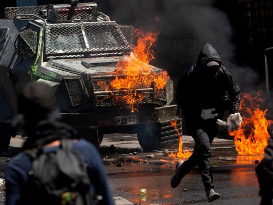 La que comenzó como una marcha de estudiantes y grupos sindicales volvió a convertir el lunes a Santiago de Chile, donde viven siete de los 18 millones de habitantes del país, en un campo de batalla. Policías reprimieron con gases lacrimógenos las protestas que comenzaron hace cuatro días y que hasta ahora han dejado 11 muertos. Fotos: Agencia AFP.