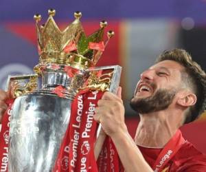 El centrocampista inglés de Liverpool Adam Lallana levanta el trofeo de la Premier League durante la presentación después del partido de fútbol de la Premier League inglesa entre Liverpool y Chelsea. Foto: AFP